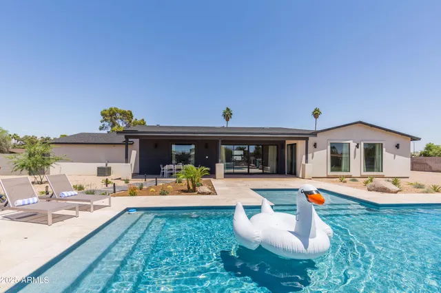 a swimming pool with outdoor seating and yard