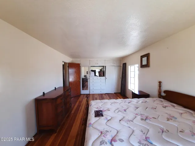 a bedroom with a bed and dresser with mirror