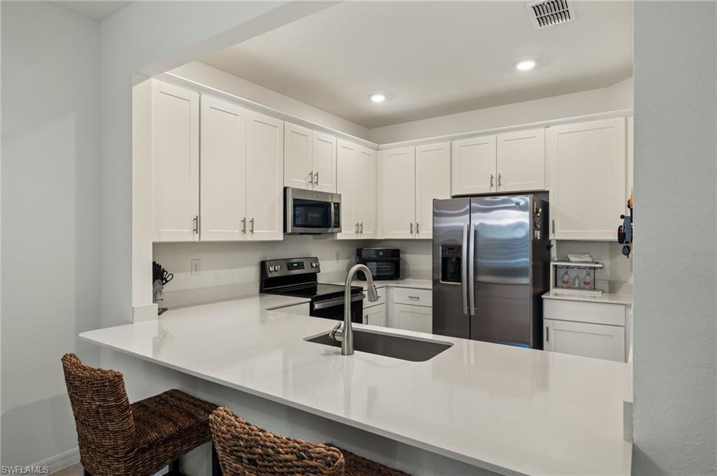 2934 Citrus Street Naples, FL 34120 - Photo 7 of 29 a kitchen with stainless steel appliances a microwave a sink and refrigerator