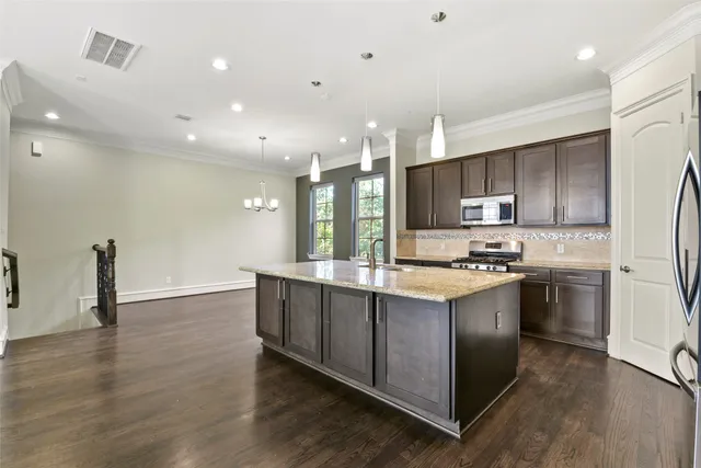 a kitchen with stainless steel appliances granite countertop a sink stove and refrigerator