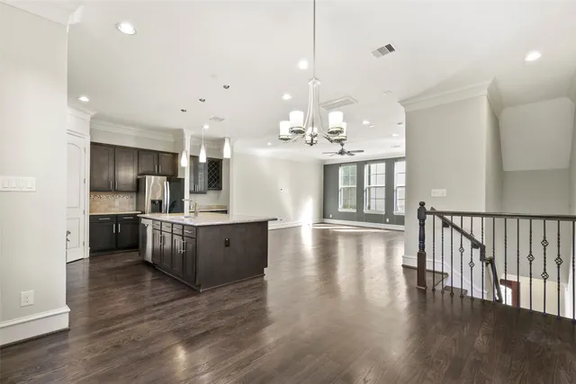 a large kitchen with cabinets wooden floor and stainless steel appliances