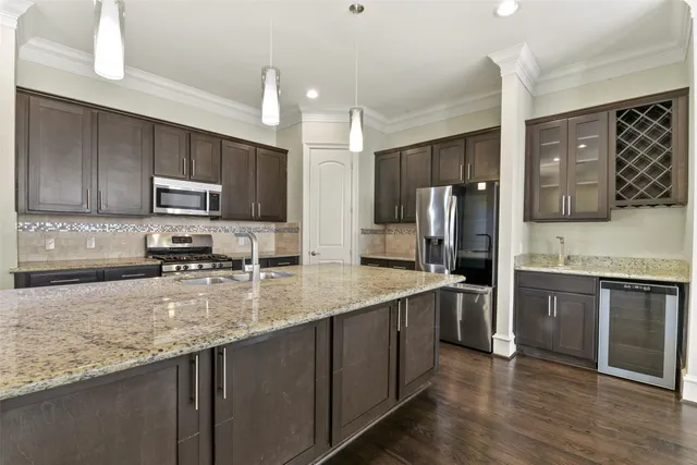 a large kitchen with stainless steel appliances granite countertop a sink stove and refrigerator