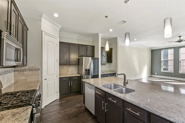 a kitchen with stainless steel appliances granite countertop a sink and a refrigerator