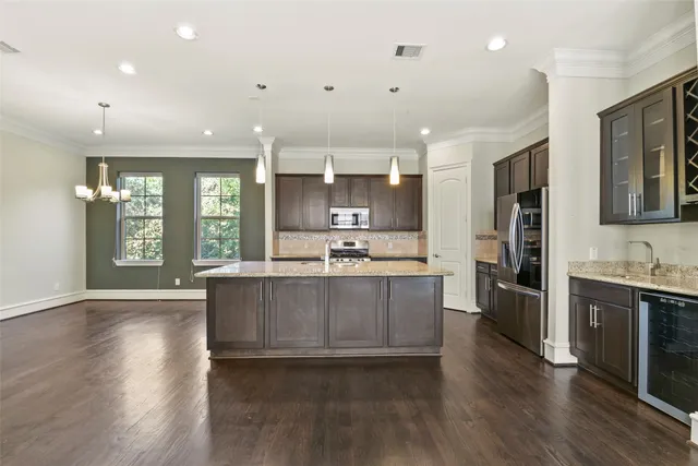 a large kitchen with stainless steel appliances granite countertop a large stove a sink dishwasher and a refrigerator with wooden floor