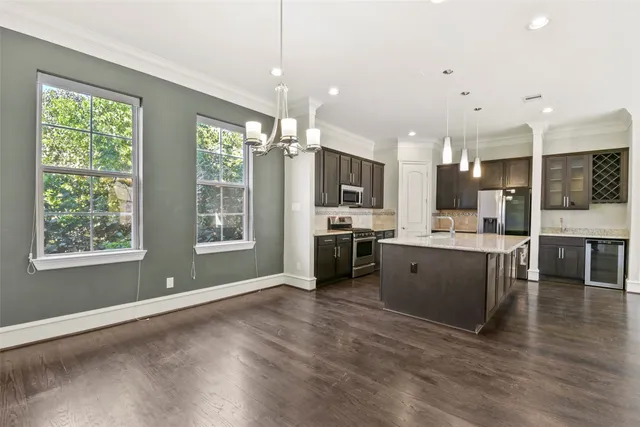a kitchen with a sink stainless steel appliances and windows
