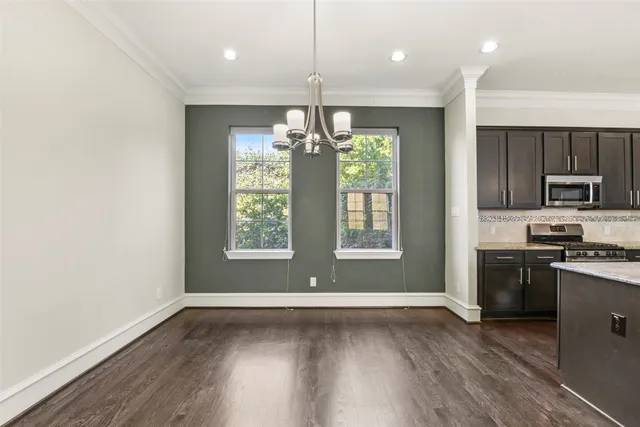 a kitchen with stainless steel appliances granite countertop a stove top oven a refrigerator with wooden floors and cabinets