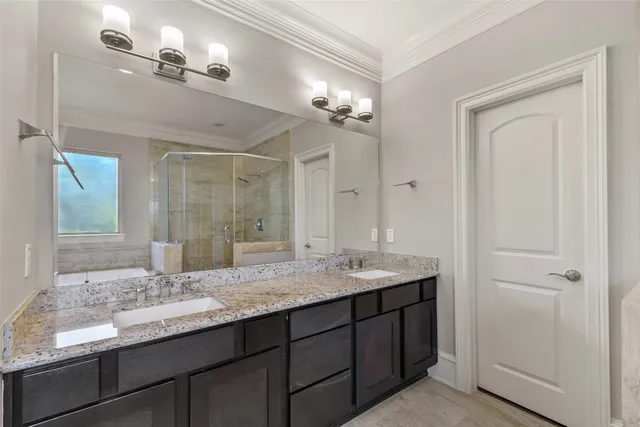 a bathroom with a granite countertop sink a large mirror and a shower