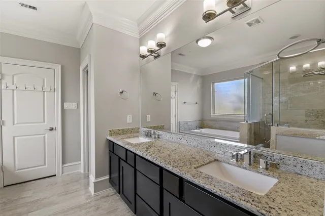 a bathroom with a granite countertop double vanity sink a mirror and shower