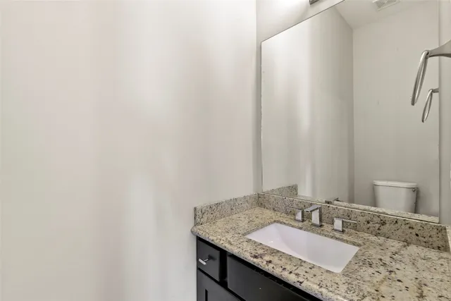 a bathroom with a granite countertop sink and a mirror