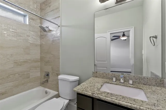 a bathroom with a granite countertop sink toilet and shower