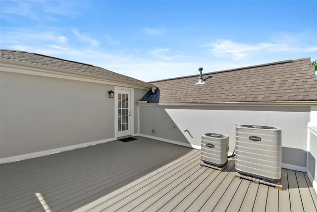a roof deck with wooden floor and fence
