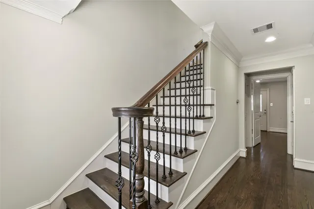 a view of staircase with wooden floor and white walls