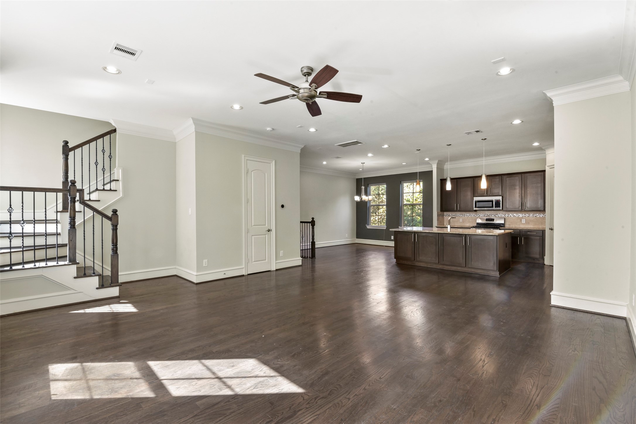 5226 Kiam Street, Unit 1018 Houston, TX 77007 - Photo 10 of 44 a view of an empty room and kitchen with sink wooden floor and windows