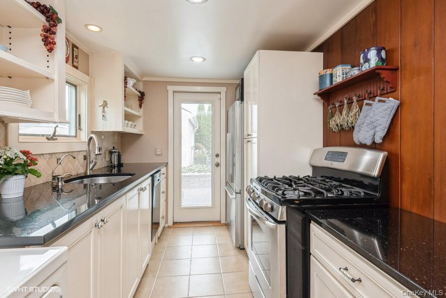 10 Stuart Avenue Babylon, NY 11702 - Photo 14 of 32 a kitchen with stainless steel appliances granite countertop a sink stove and refrigerator