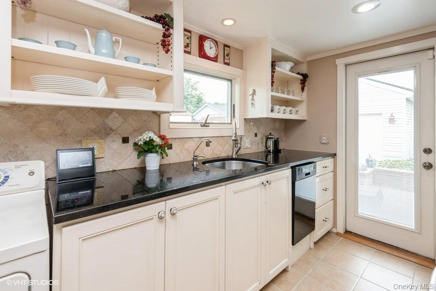 10 Stuart Avenue Babylon, NY 11702 - Photo 15 of 32 a kitchen with stainless steel appliances a sink a window and cabinets