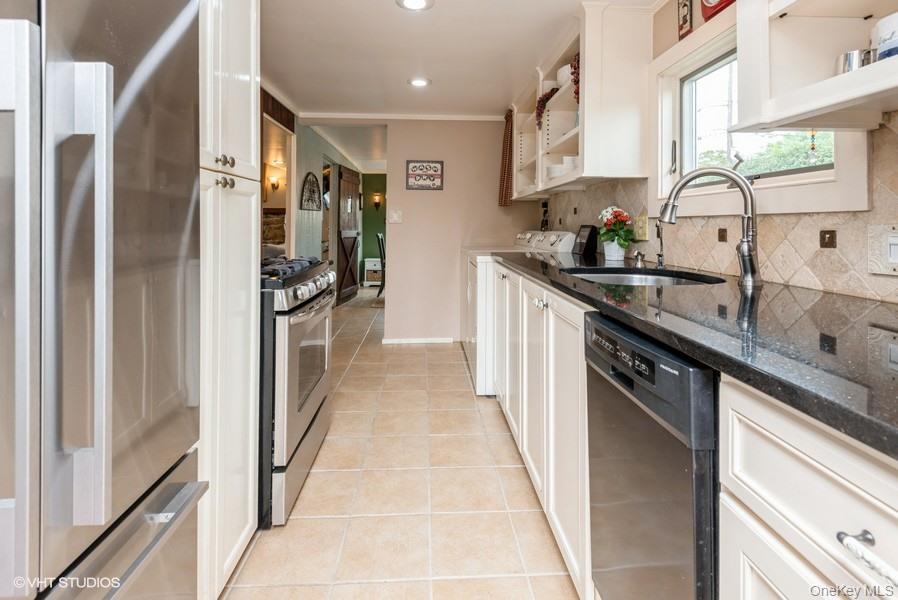 10 Stuart Avenue Babylon, NY 11702 - Photo 16 of 32 a kitchen with stainless steel appliances granite countertop a sink and a refrigerator