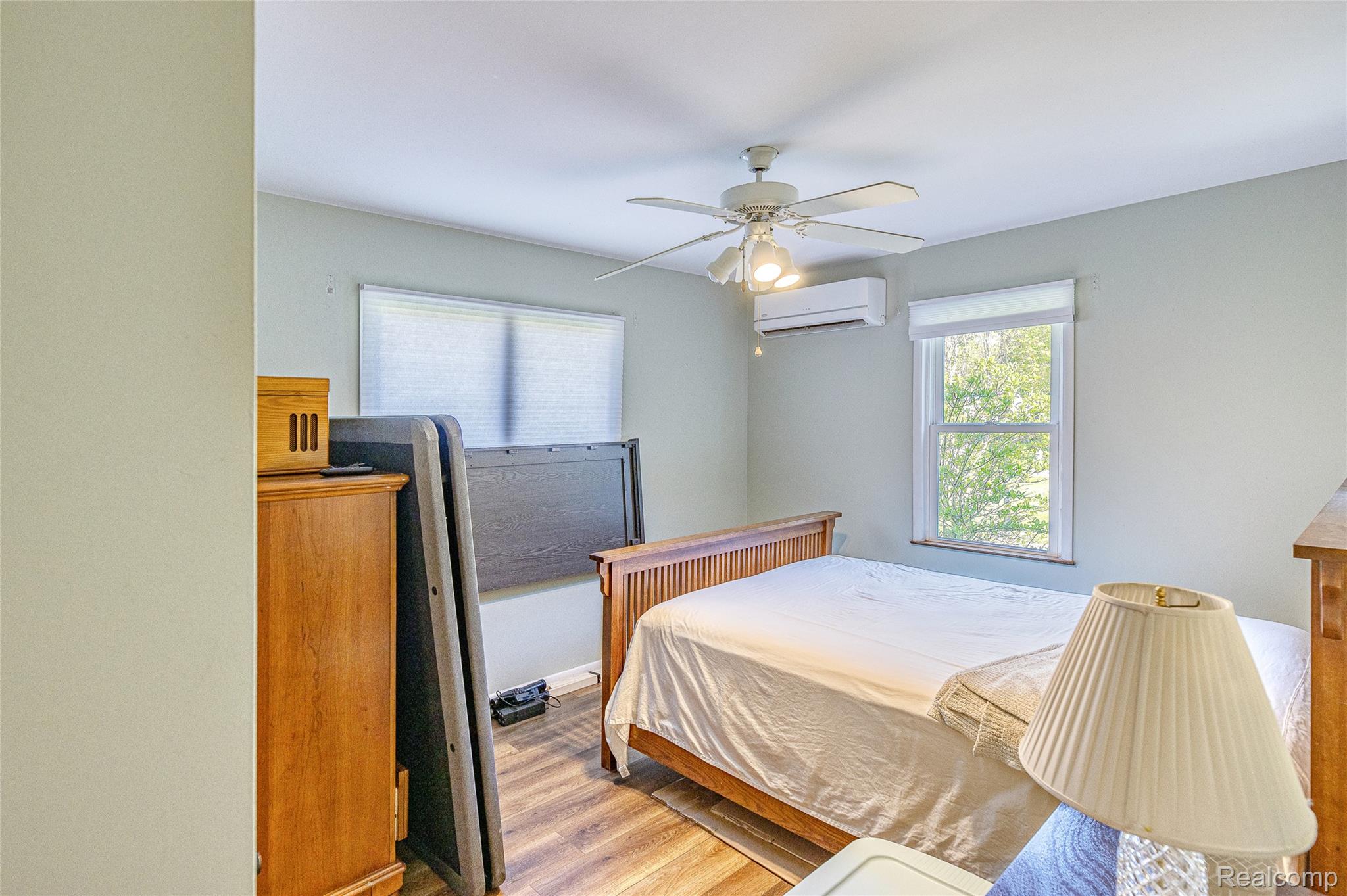 2855 Farmers Creek Road Metamora, MI 48455 - Photo 17 of 51 Bedroom featuring wood-finish flooring, two windows with white blinds, and a ceiling fan with integrated lighting