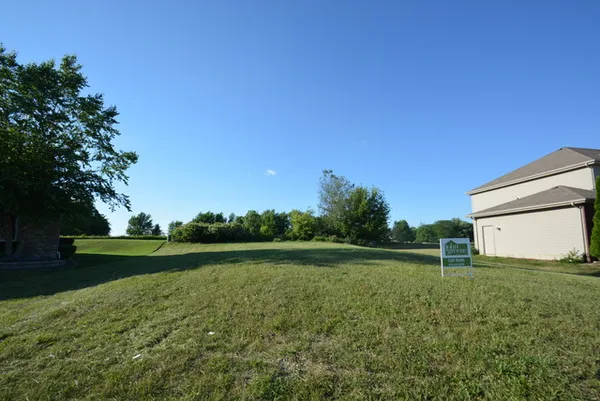 a backyard of a house with lots of green space and lake view