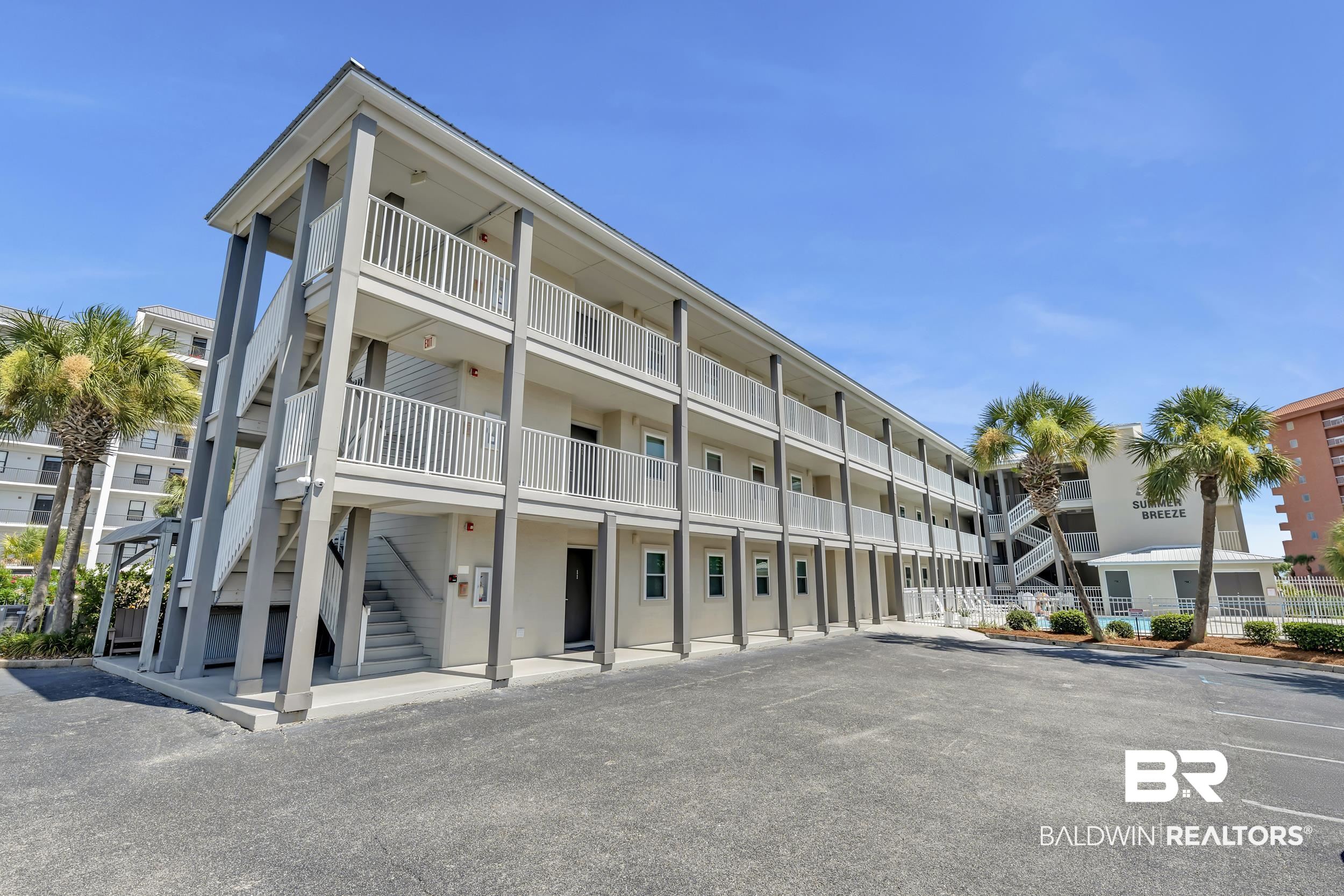 27222 Gulf Road, Unit 33 Orange Beach, AL 36561 - Photo 6 of 29 Multi-story property featuring exterior stairwells, individual balconies, and a paved parking area