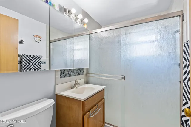a bathroom with a sink vanity and a shower
