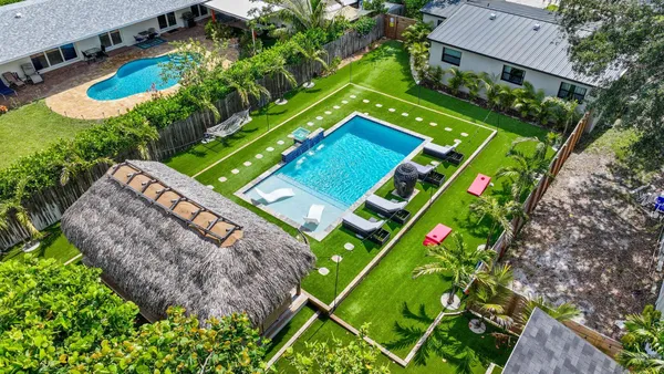 an aerial view of residential houses with outdoor space and trees