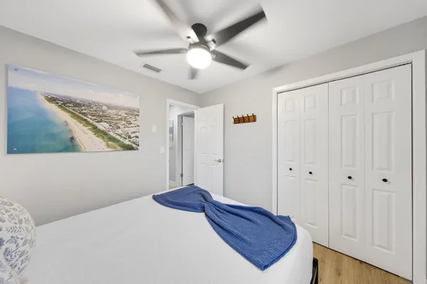 a living room with a flat screen tv and a ceiling fan