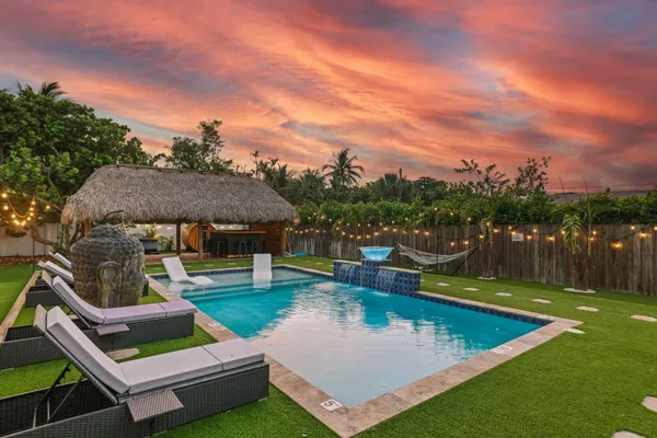 a view of a swimming pool with lounge chairs in patio