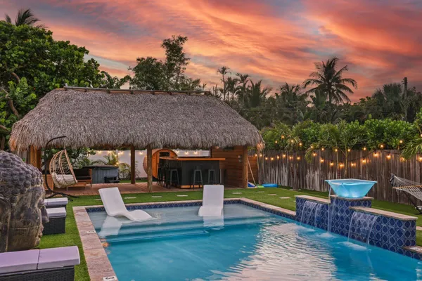 a view of a house with swimming pool and sitting area