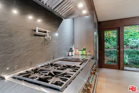 a stove top oven sitting inside of a kitchen