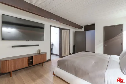 a bedroom with a bed and a flat screen tv