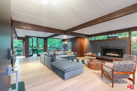 a living room with furniture large window and a fireplace