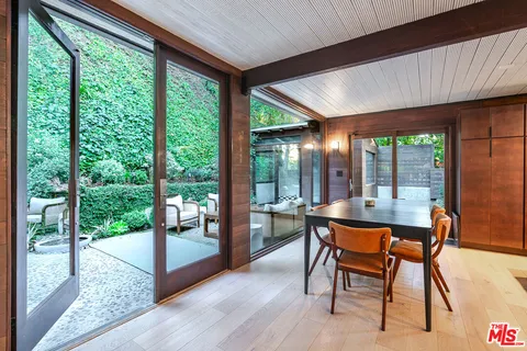 a dining room with furniture wooden floor and a floor to ceiling window