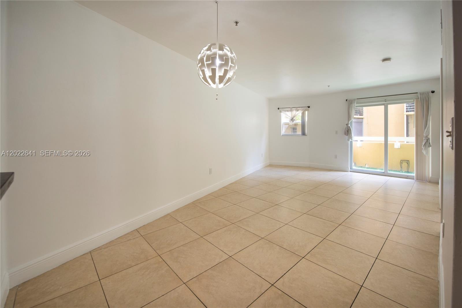 4147 Stirling Road, Unit 105 Dania Beach, FL 33314 - Photo 5 of 16 an empty room with windows and chandelier