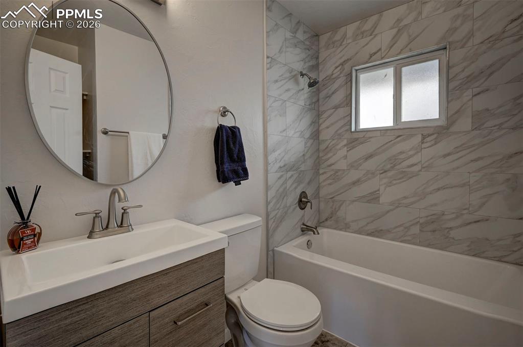 701 Erie Road Colorado Springs, CO 80910 - Photo 16 of 27 a bathroom with a sink a mirror a toilet and bathtub