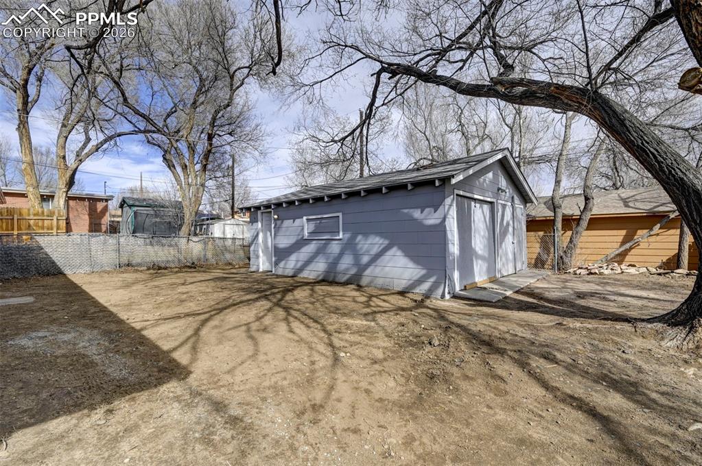 701 Erie Road Colorado Springs, CO 80910 - Photo 26 of 27 a backyard of a house with large trees and outdoor seating