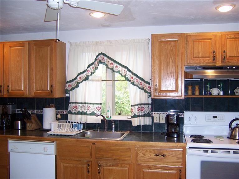 47 Chipman Road Sandwich, MA 02563 - Photo 15 of 31 a kitchen with kitchen island granite countertop a stove a sink and a microwave