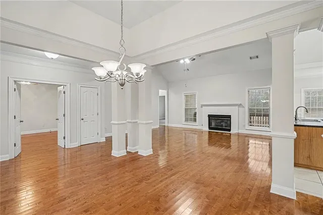 a view of a livingroom with a fireplace a chandelier and wooden floor