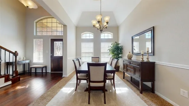 a view of a dining room with furniture a chandelier and wooden floor