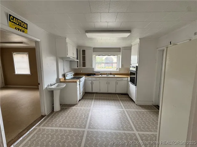 a kitchen with a sink a refrigerator and cabinets
