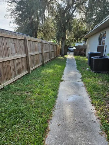 a view of a house with a small yard and wooden fence