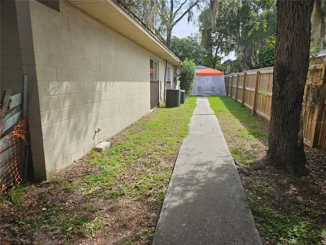 a backyard of a house with fountain table and chairs