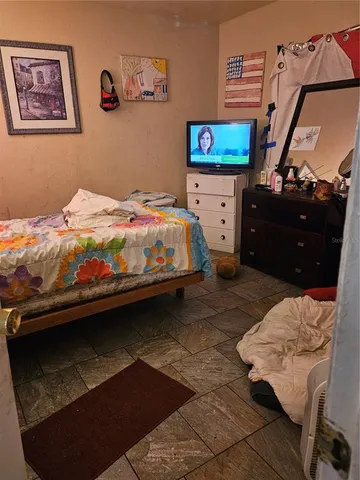 a bedroom with a bed and a flat screen tv
