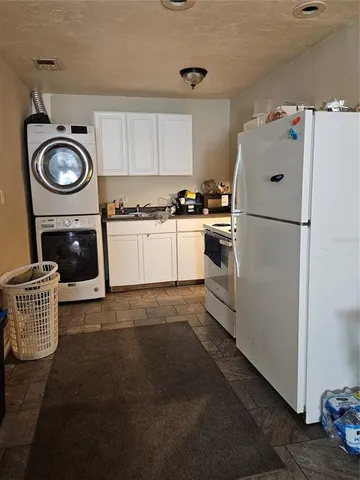 a kitchen with a refrigerator a stove top oven and cabinets