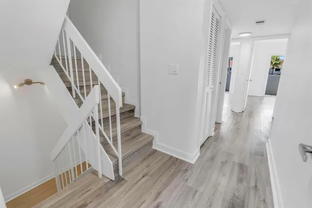 a view of a hallway with wooden floor and entryway