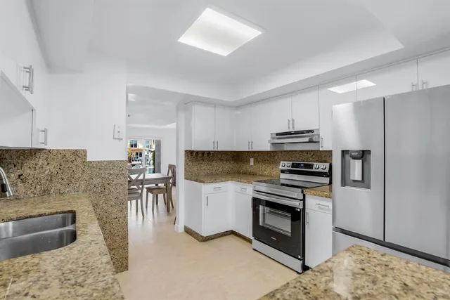 a kitchen with a stove a sink and a refrigerator