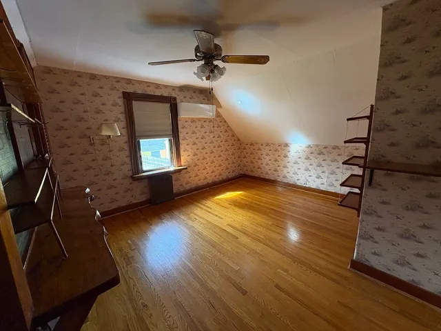 a view of a livingroom with wooden floor and a ceiling fan
