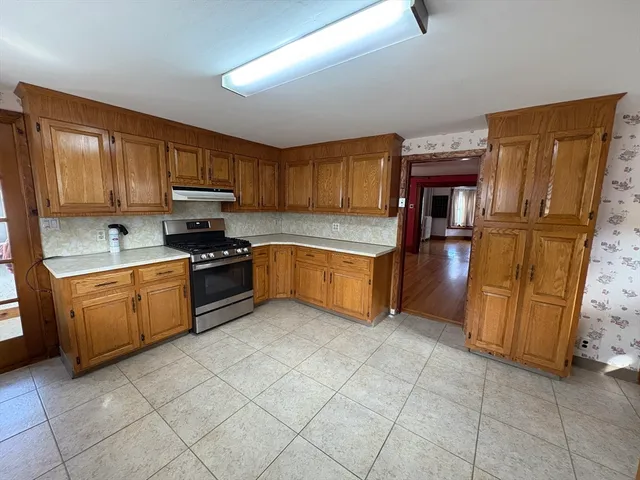 a kitchen with granite countertop a refrigerator and a stove top oven