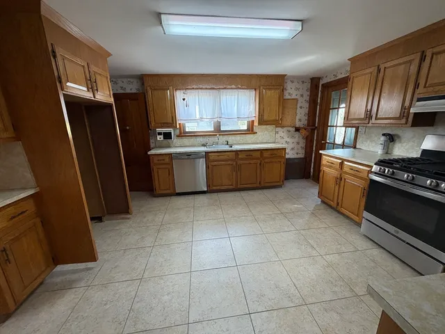 a kitchen with stainless steel appliances granite countertop a refrigerator stove and sink