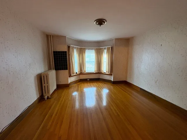 a view of a livingroom with wooden floor and a window
