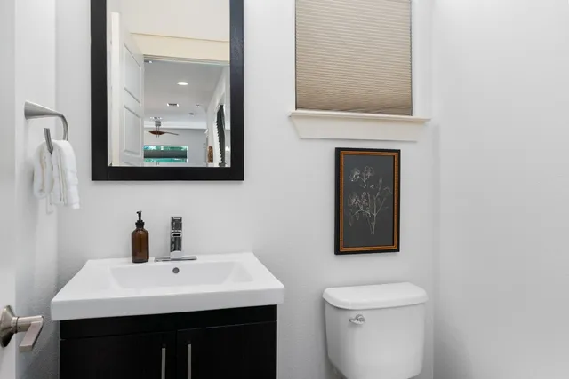 a bathroom with a toilet a sink and mirror